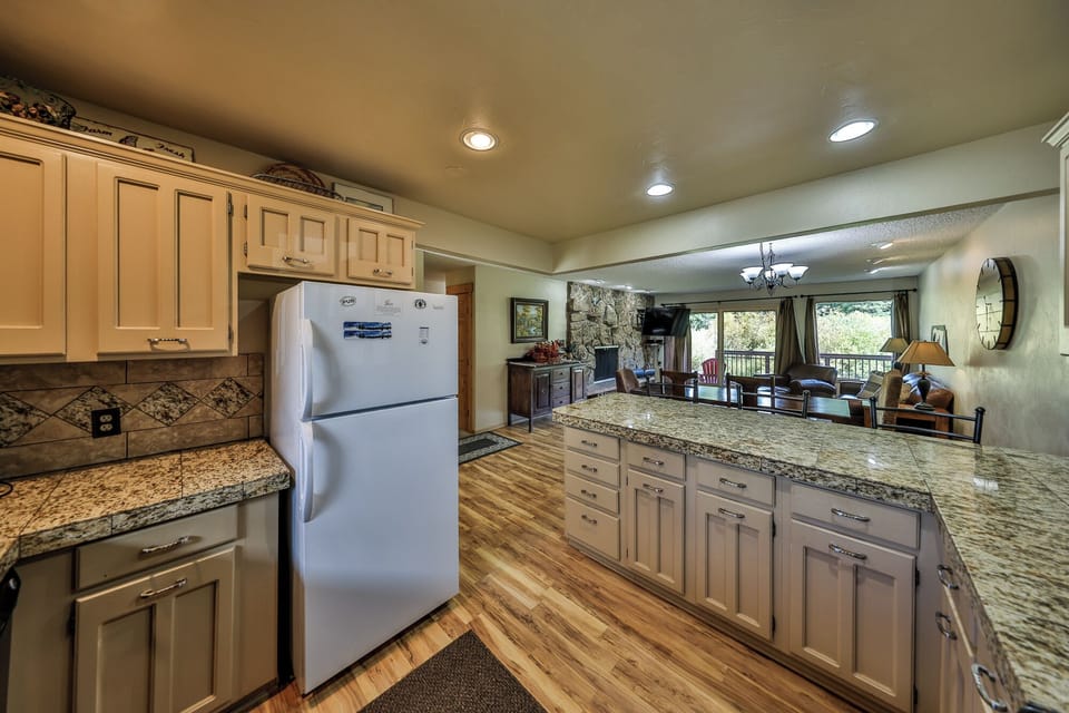 Your spacious kitchen flows seamlessly into the living area, where granite counters and warm wood create the perfect space for cooking together.