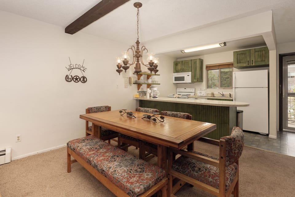 Gather around your rustic dining table for hearty meals, with a fully equipped kitchen featuring sage-green cabinets ready for your culinary adventures.