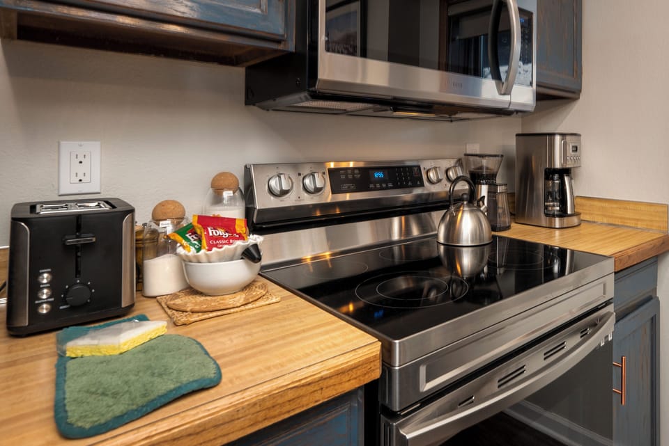 Your fully equipped kitchen awaits with stainless steel appliances and warm wood countertops, perfect for brewing morning coffee or preparing homemade meals.