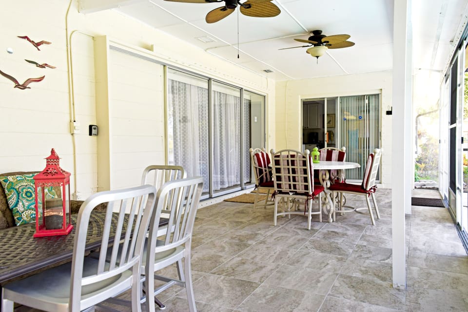 renovated lanai with dining table and coffee table and couch