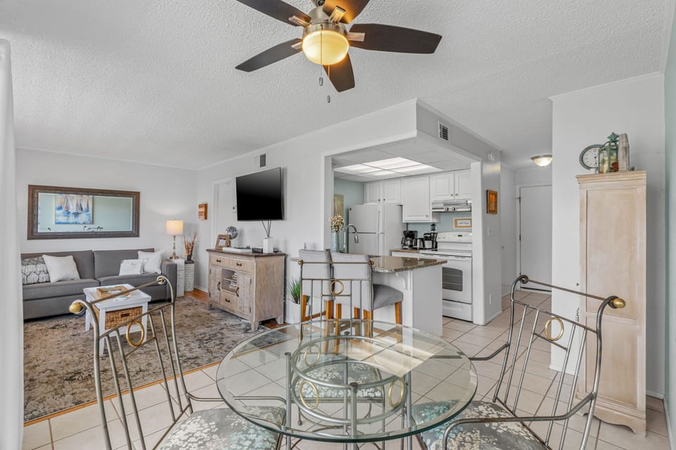 Relax in your stylish open-concept space with coastal decor, where the kitchen flows into your dining and living areas.