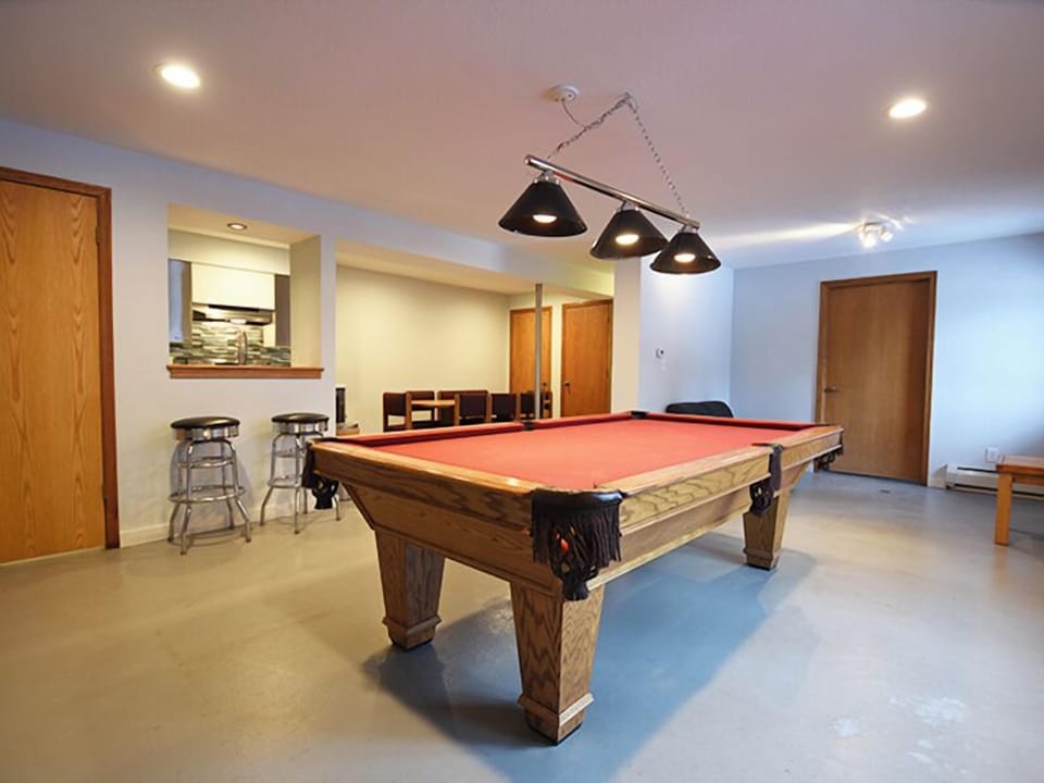 Challenge friends to a game at your private pool table, perfectly lit for competitive play in this spacious entertainment room.