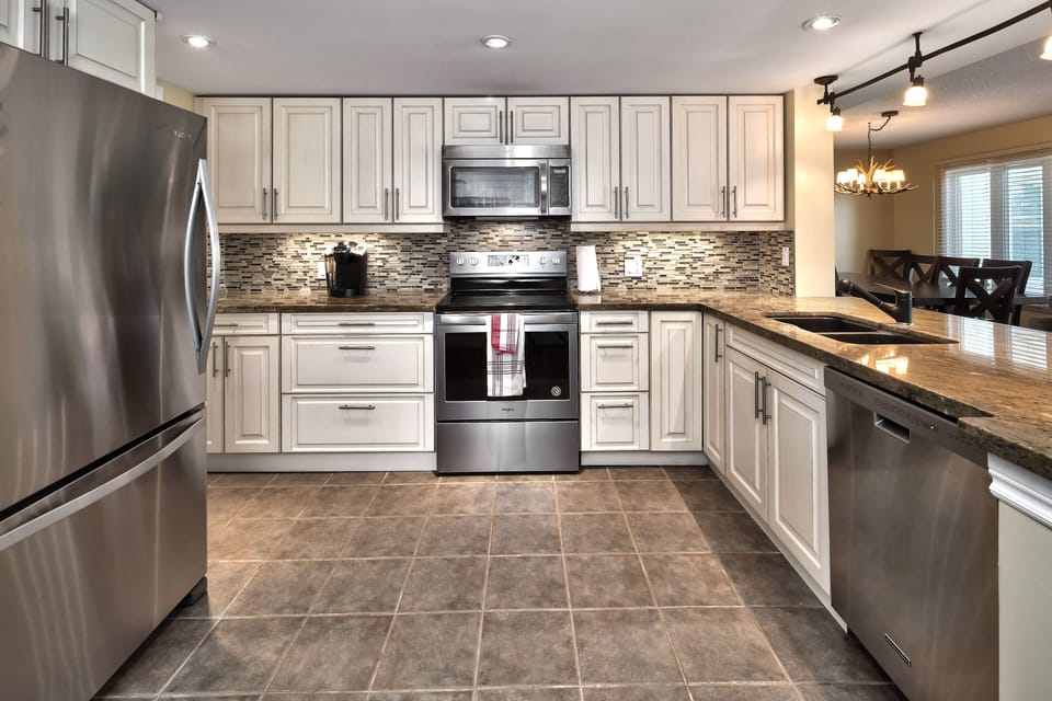 Renovated kitchen has upgraded cabinetry, stainless steel appliances and granite