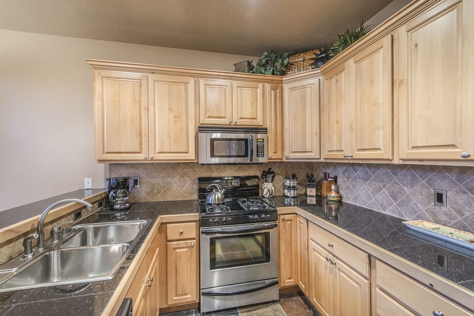 Kitchen - Granite counters, stainless steel appliances, and double sinks.