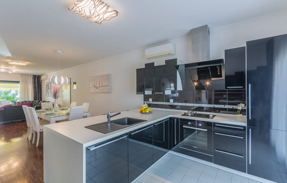 Fully equipped kitchen with dishwasher, refrigerator, microwave, gas hob, oven.