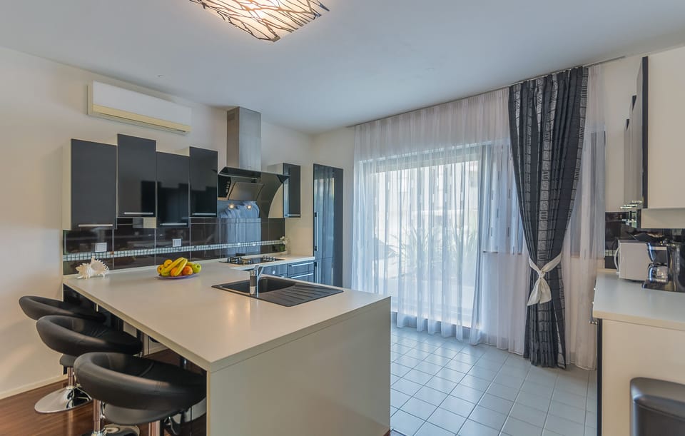 Fully equipped kitchen with dishwasher, refrigerator, microwave, gas hob, oven.