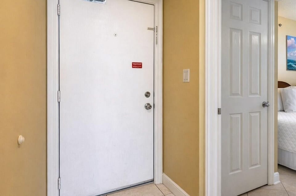 This inviting entryway leads to a cozy guest bedroom featuring a comfortable bed and charming nautical decor