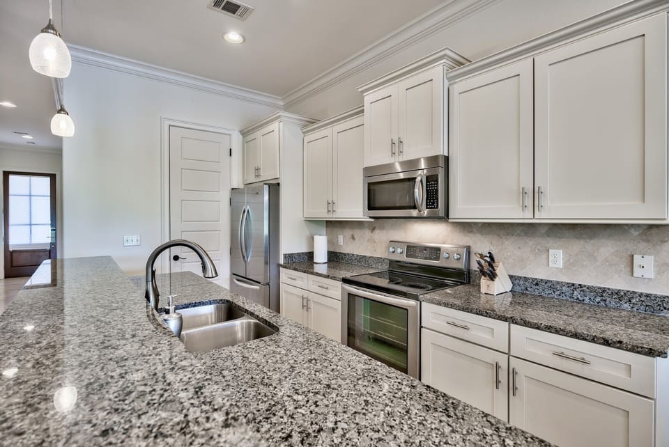 Open concept kitchen stocked with lots of cookware, coffee makers, grinder, wine chiller fridge, blender, etc.