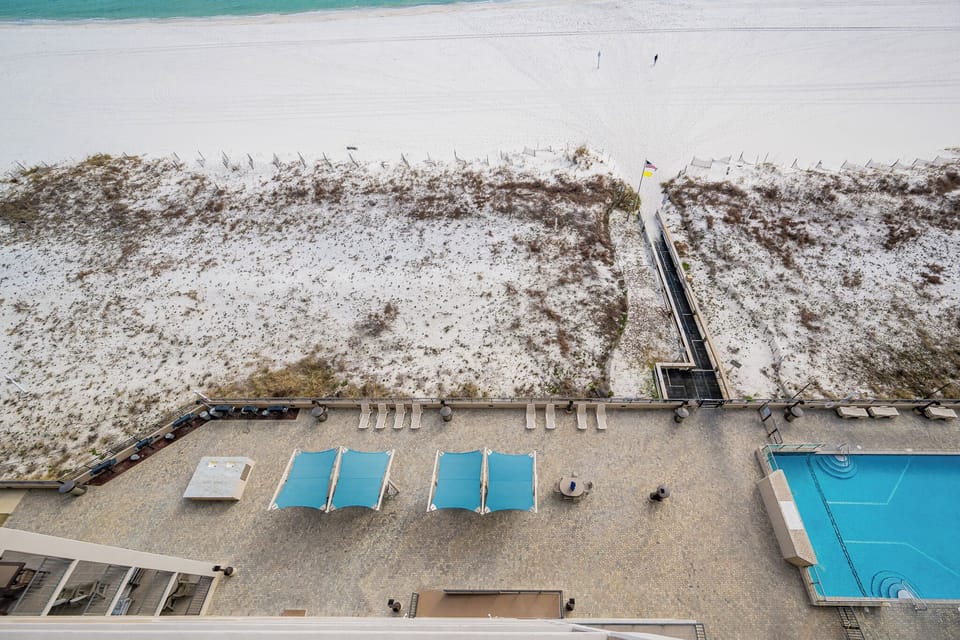 Cool pool waters invite you to lounge on shaded chaises while soft coastal air brushes the beach dunes