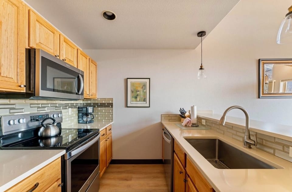 Updated, well-stocked galley kitchen with bar top / 3 stools.