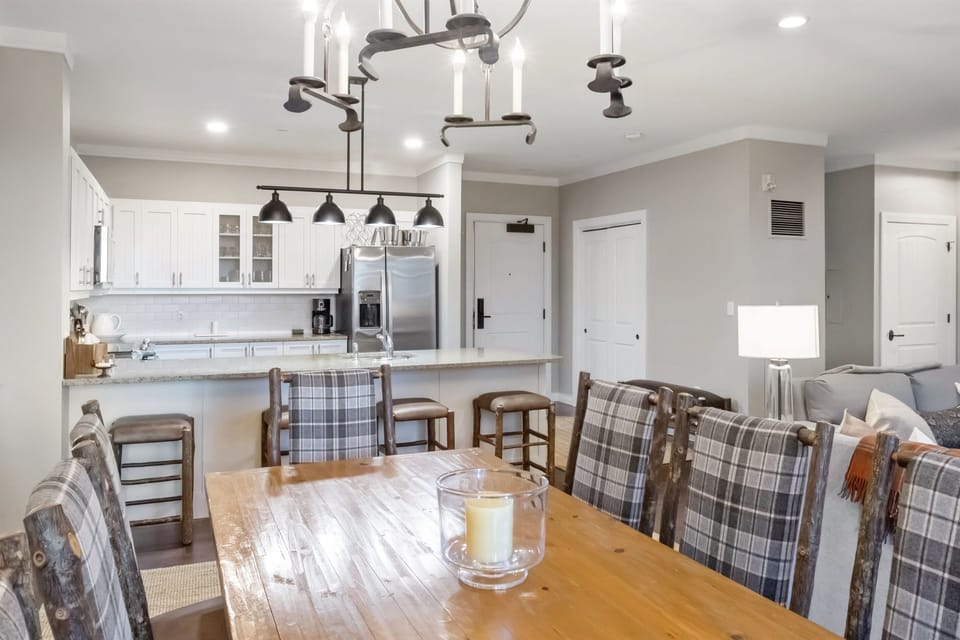 - Open dining area with rustic wood table and plaid chairs   - Overlooks modern kitchen with stainless steel appliances   - Perfect for family dinners after mountain adventures