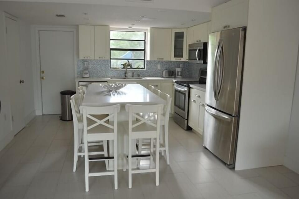 Eat in kitchen with white quartz countertops and stainless steel appliances.