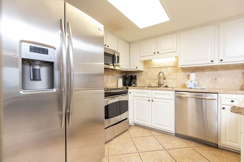 Prepare meals in this bright kitchen featuring stainless appliances, ample counter space, and stylish cabinetry