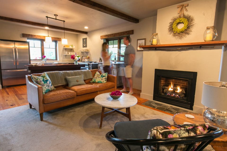A couple enjoying some wine between the living room and open kitchen.