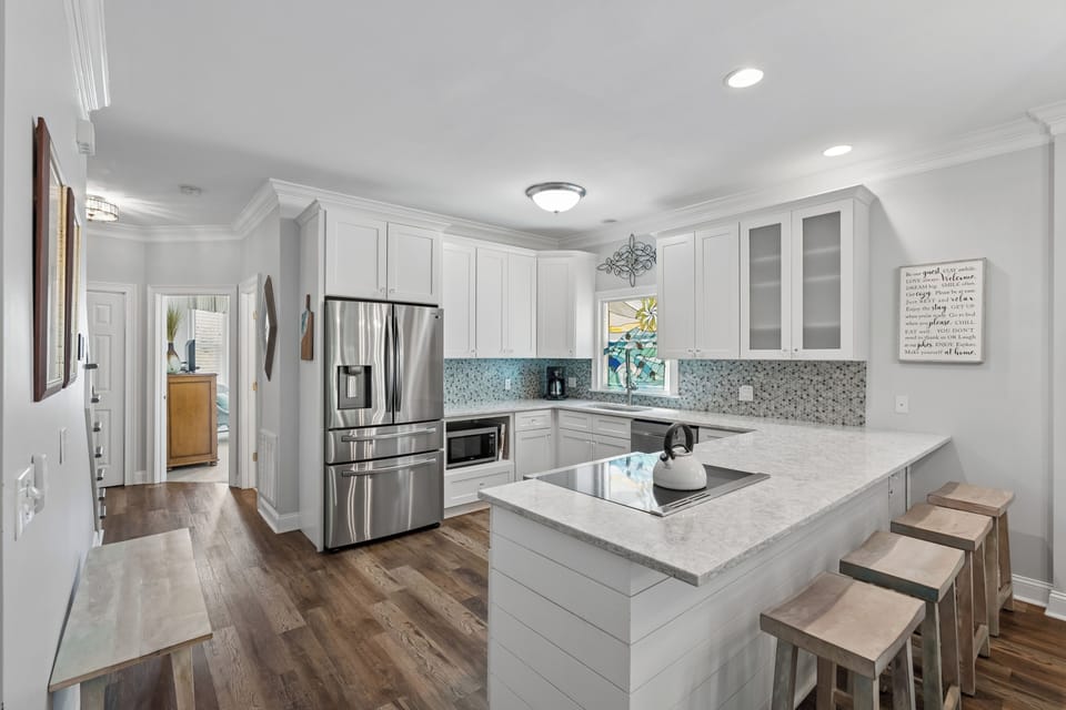Your private chef's kitchen awaits—gleaming granite counters, stainless steel appliances, and a sunny breakfast island where you can sip morning coffee while planning your day's adventures.