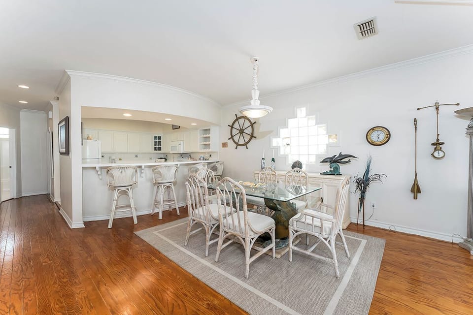 Dining space seats six with nautical accentsâ€”ideal for family dinners or holiday breakfasts overlooking the beach.