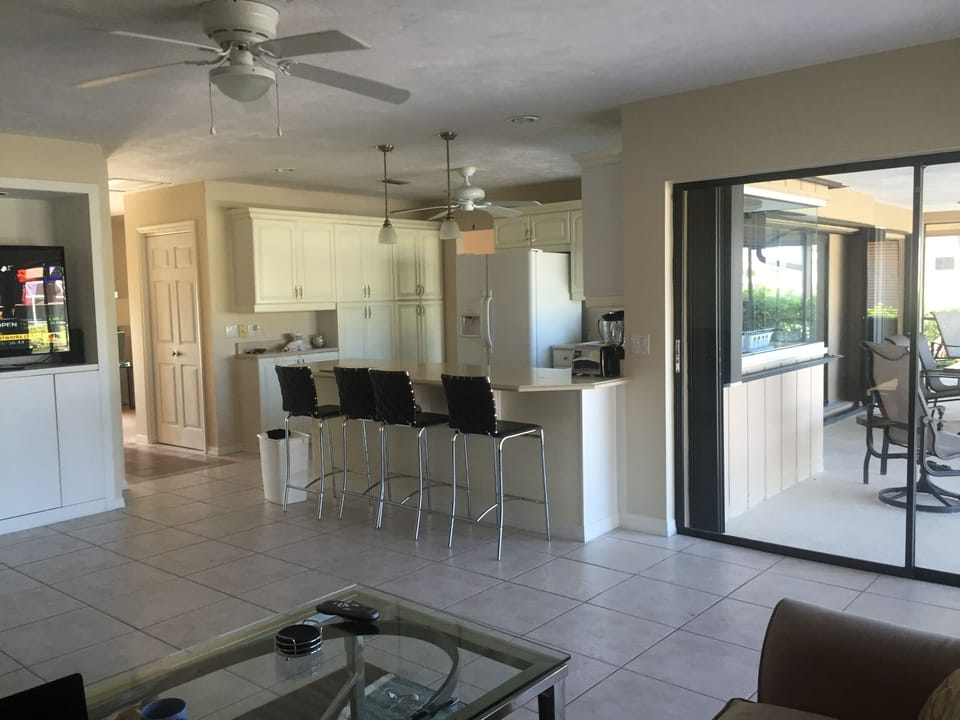 Family room area with 2 sofas, 55" TV, large kitchen countertop.