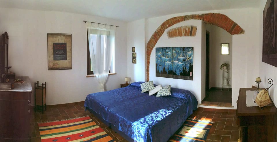 Wide view of the bedroom with the king size bed and the antique furniture