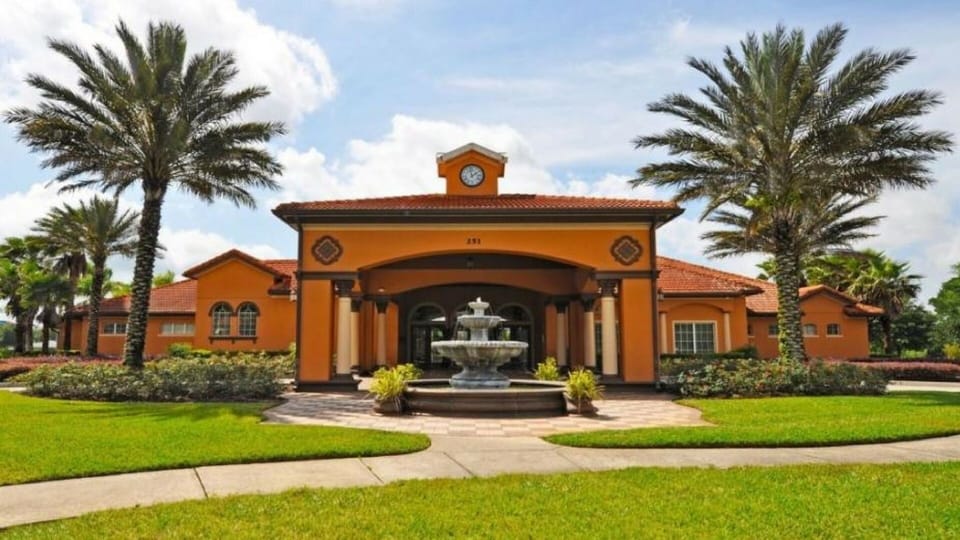 The clubhouse is surrounded by soaring palm trees, flowers and manicured gardens
