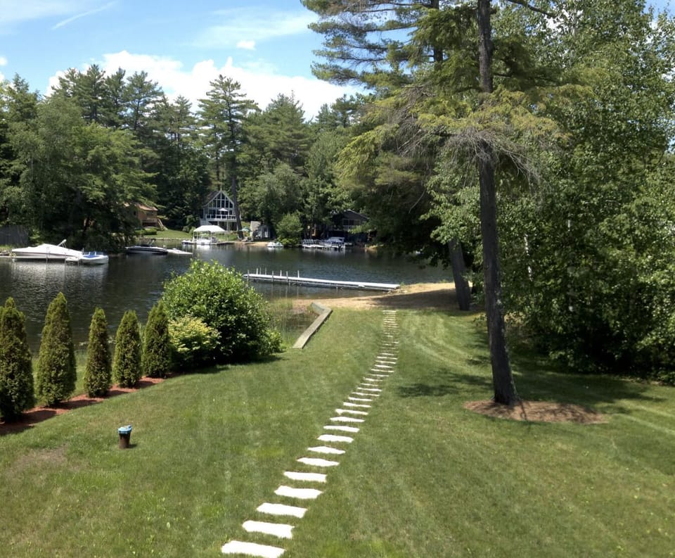 Large, level back yard with manicured landscaping, leads to natural sand beach