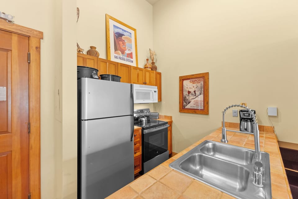 Whip up your favorite meals in this well-appointed kitchen featuring stainless steel appliances, warm wood cabinetry, and everything you need.