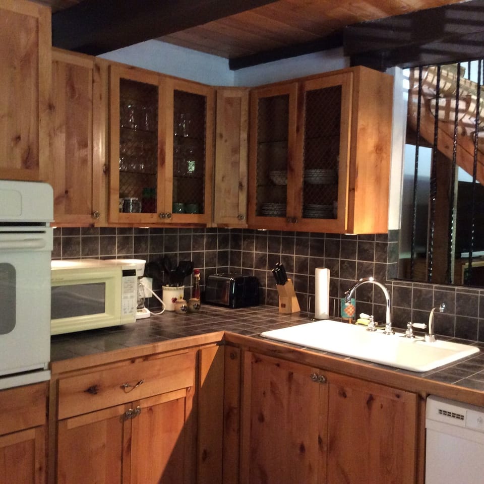 NUMEROUS KITCHEN APPLIANCES: gas oven, microwave, dishwasher, coffee machine, stove, refrigerator, toaster, and cookware.