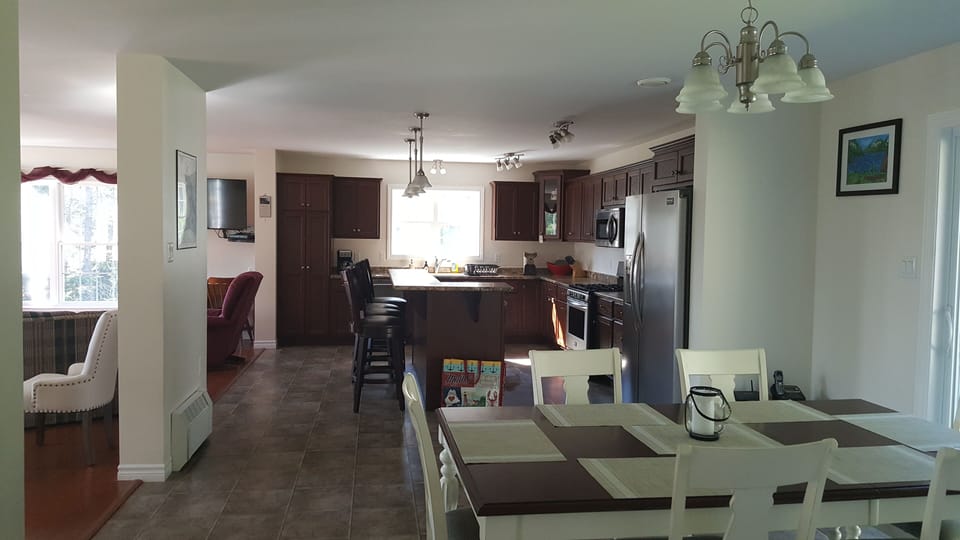 Open dining and kitchen into living room from side entrance hall