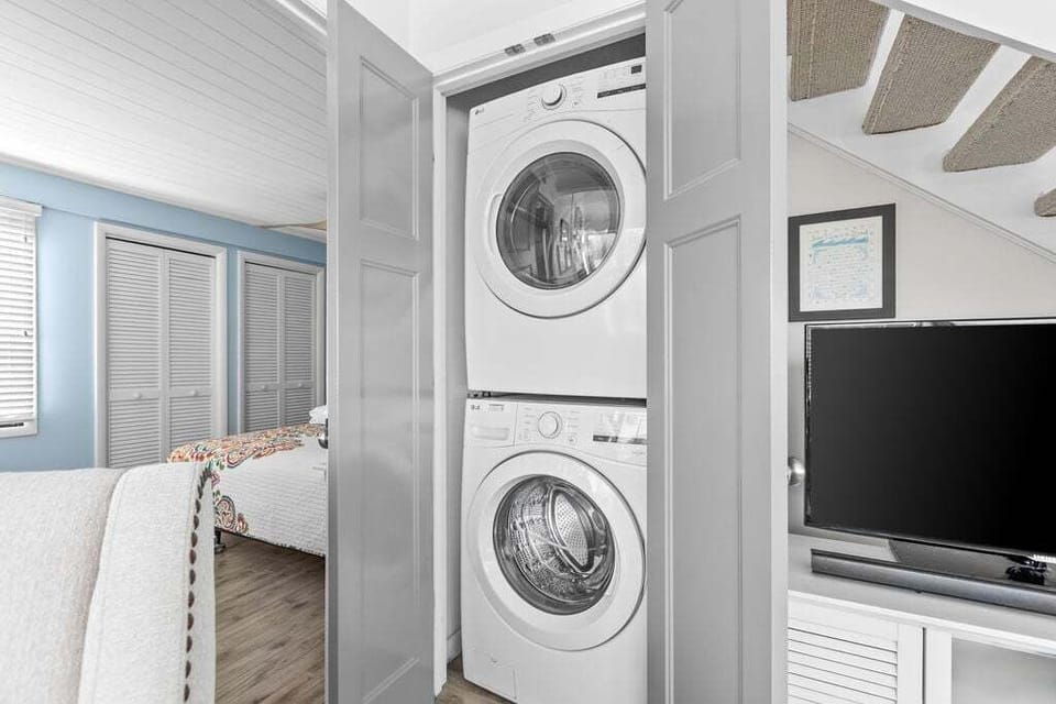Full laundry facility off the living room outside the primary bedroom