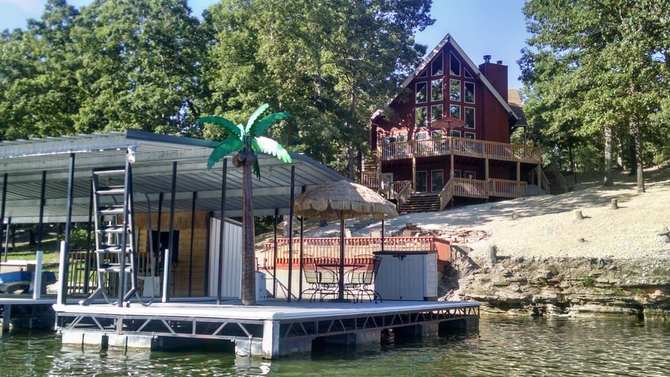 View of home as seen from water. Swim platform and tiki bar on dock.