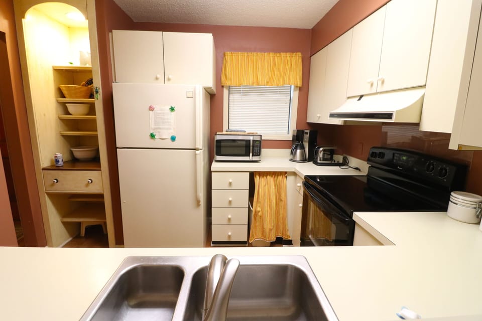 Full Kitchen and Open Shelving - Kitchen angle showing open shelving, full-size appliances, sink, and prep space.