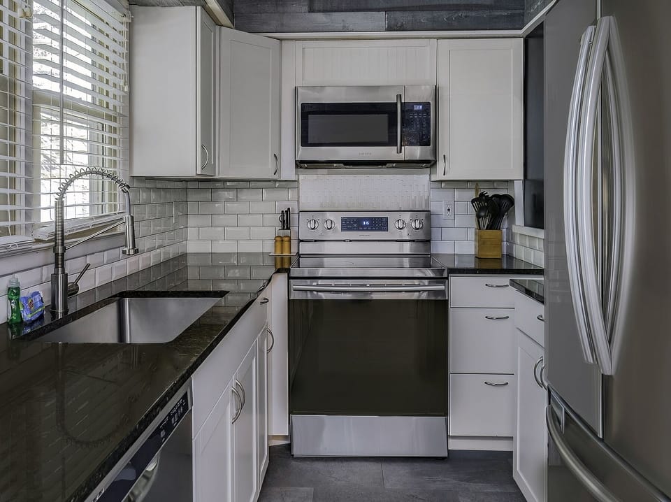 New counter tops, painted cabinets and appliances in the kitchen.