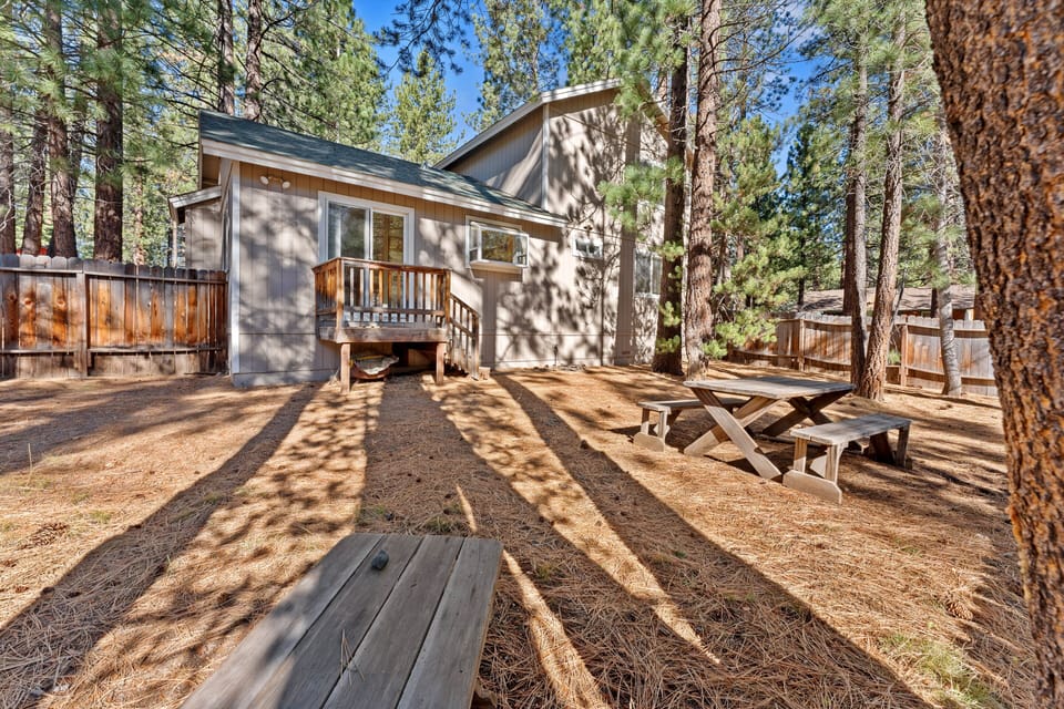 Backyard includes trees, sliding door, deck, and stairs.