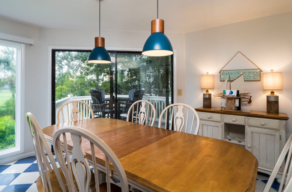The dining area has a table that seats 6. The sliding doors lead to a deck.