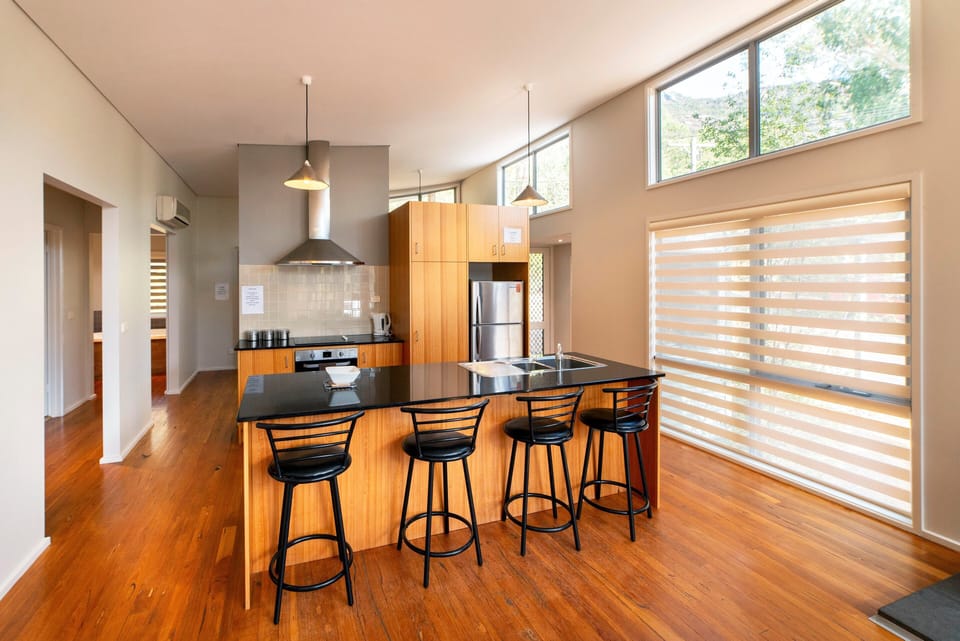 Heart of home: Sleek kitchen, modern amenities, four stylish bar stools. Culinary joy awaits! 