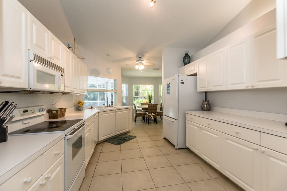 Open kitchen with breakfast nook and french doors to pool area.