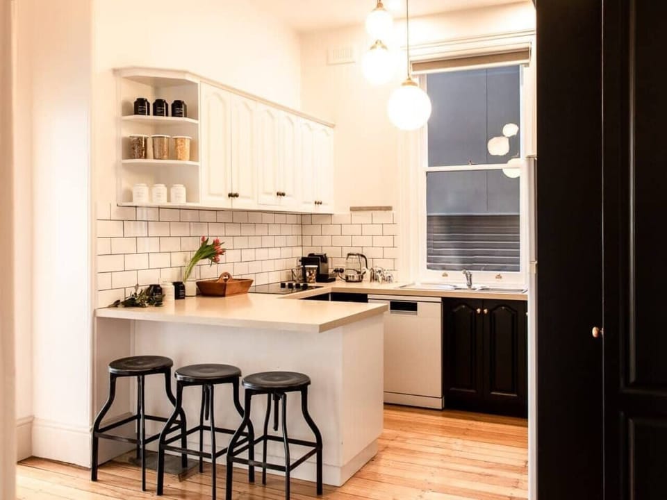The sleek black-and-white kitchen invites you to test your culinary creativity with premium appliances and ample bench space.