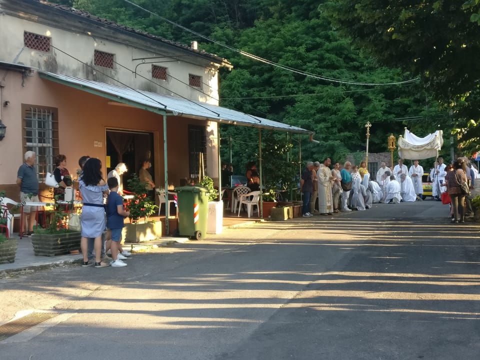 The village bar and a religious procession on the bridge.