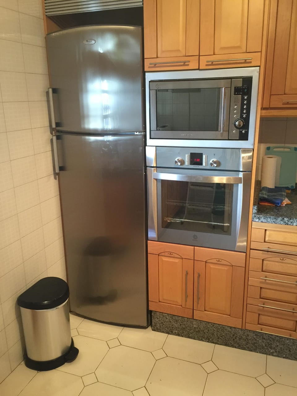 There is a large fridge/freezer in the kitchen with a big oven and microwave