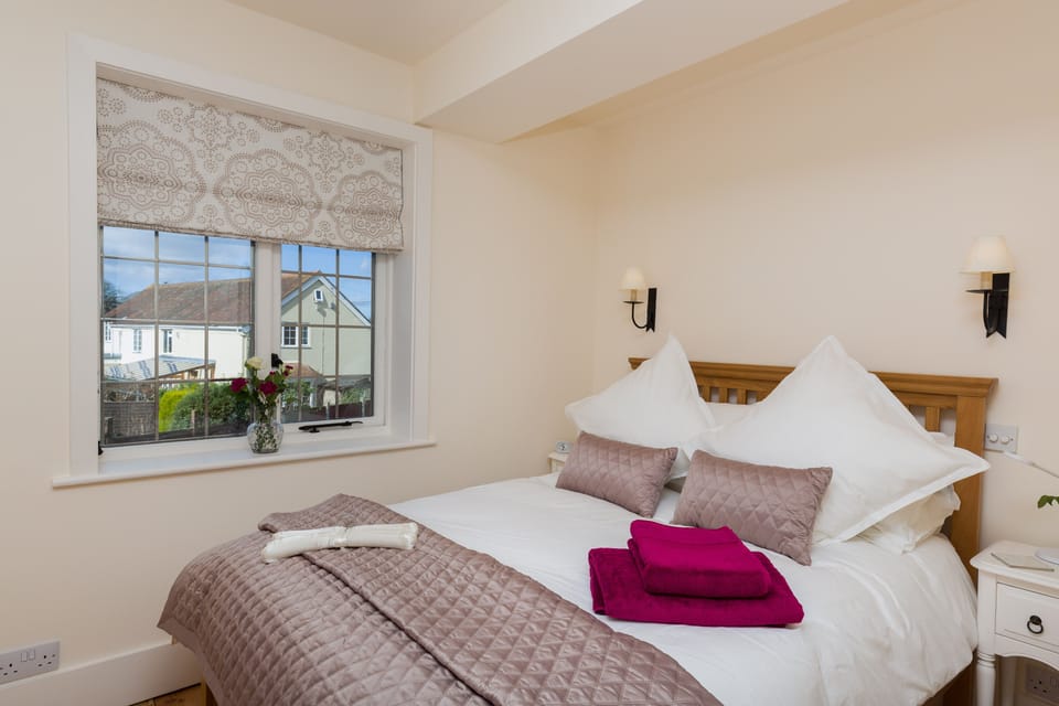 The oak double bedstead has luxury cotton bed linen. Choose the warm wall lights with dimmer or bedside reading lights