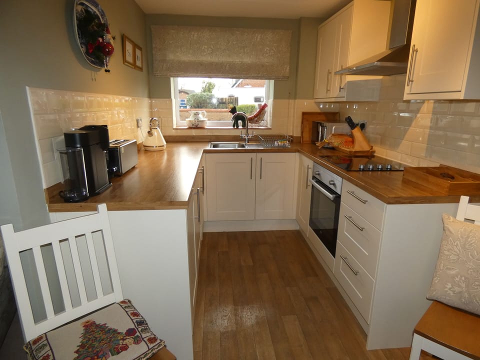 Fully equipped kitchen with fitted cabinets, hob, oven and extractor.
