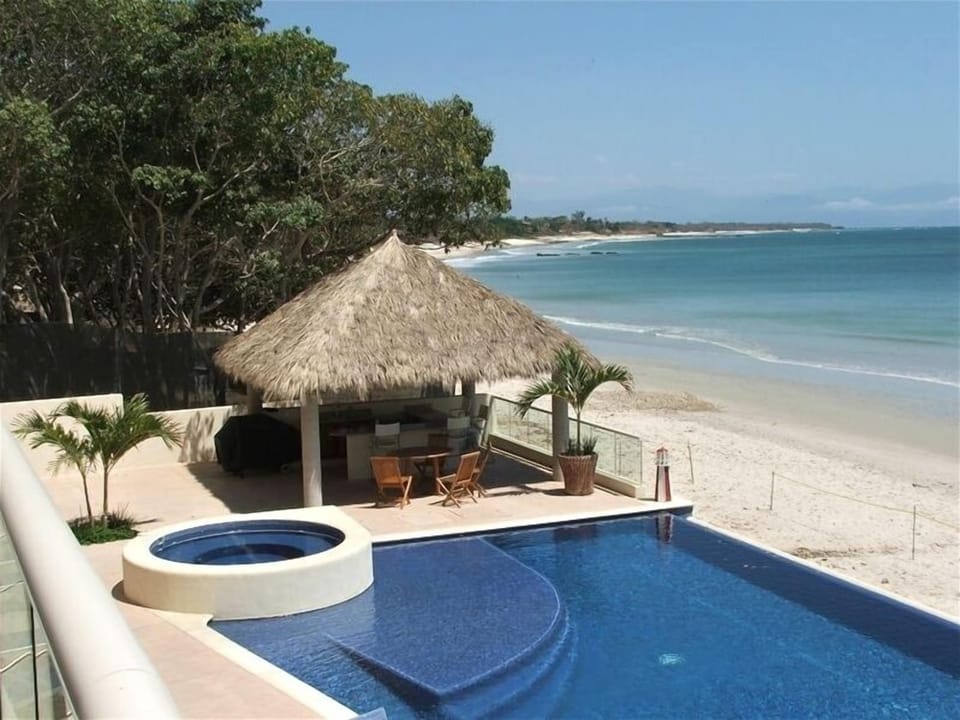 The outdoor kitchen, palapa, infinity pool, and hot tub await you!