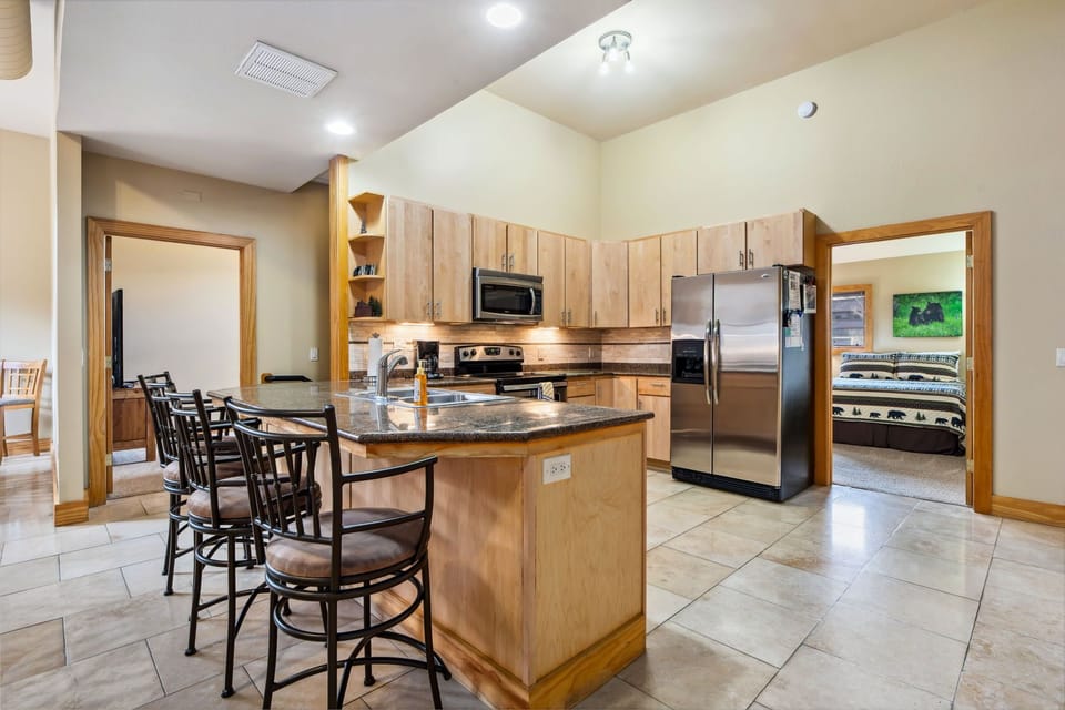 Four bar stools for additional seating. Granite counters & travertine tile floor
