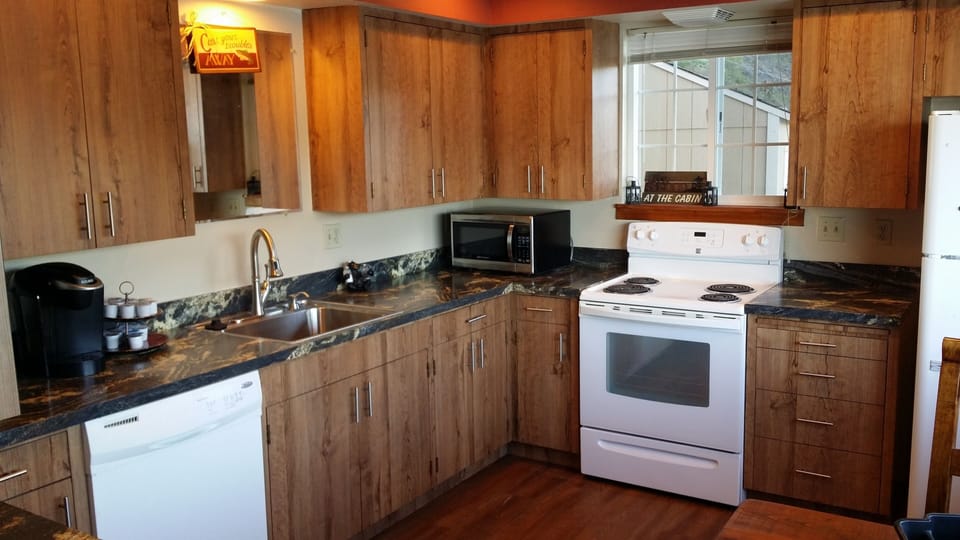 Well appointed kitchen with cooking utensils, silverware, plates, etc.