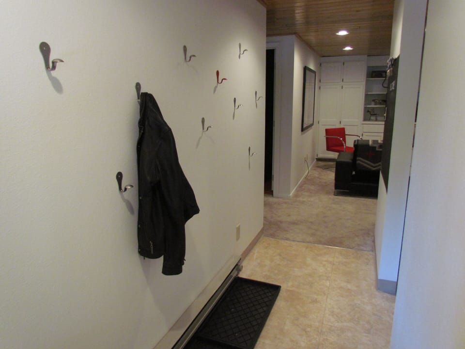 Entryway with an abundance of hooks and boot/shoe area