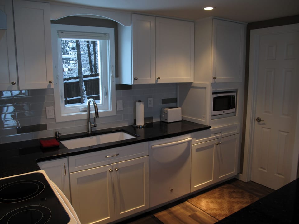 A granite sink, full-size dishwasher and microwave complete the kitchen setup.