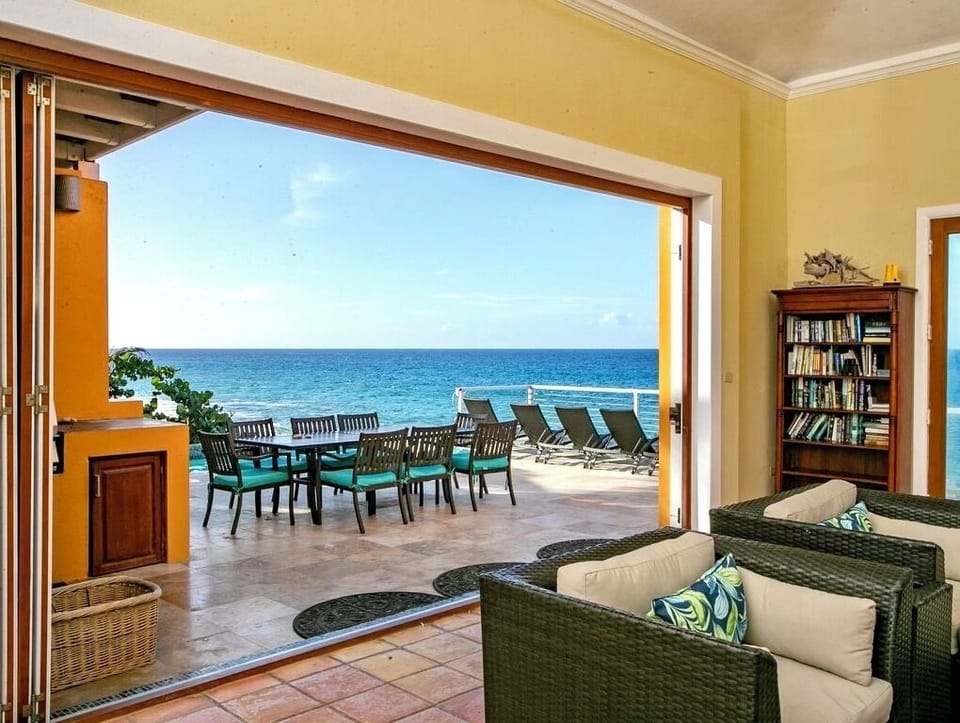 Living room that opens up to the large pool deck and outdoor kitchen