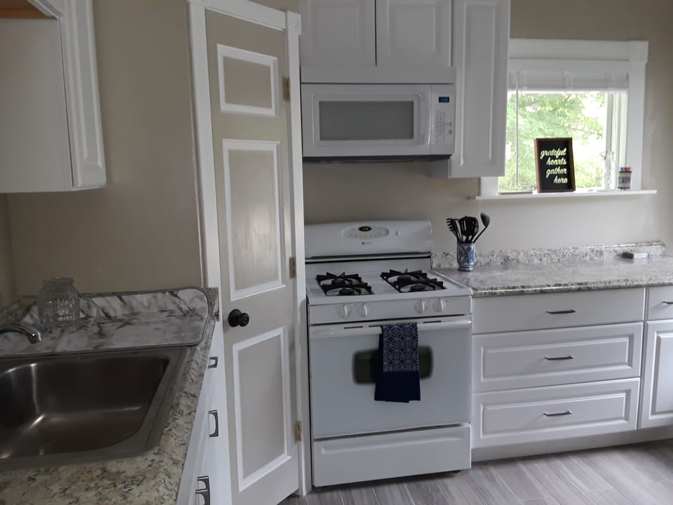 Fully stocked kitchen with microwave and Keurig coffee maker, plus dishware etc
