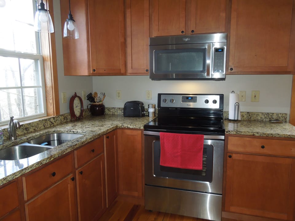 Well-equipped kitchen with new stainless appliances and granite countertops. 