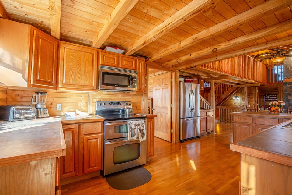 Large well equipped kitchen with dishes, pots and pans and silverware. 