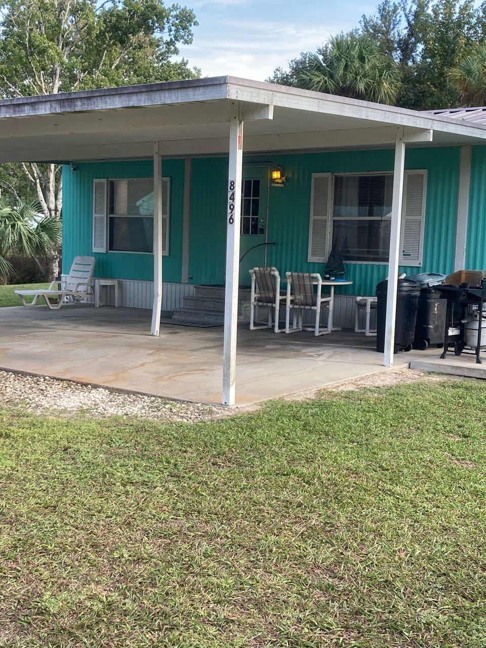 Front entrance w/carport door lockbox, bbq n out side table & chairs.Water view.